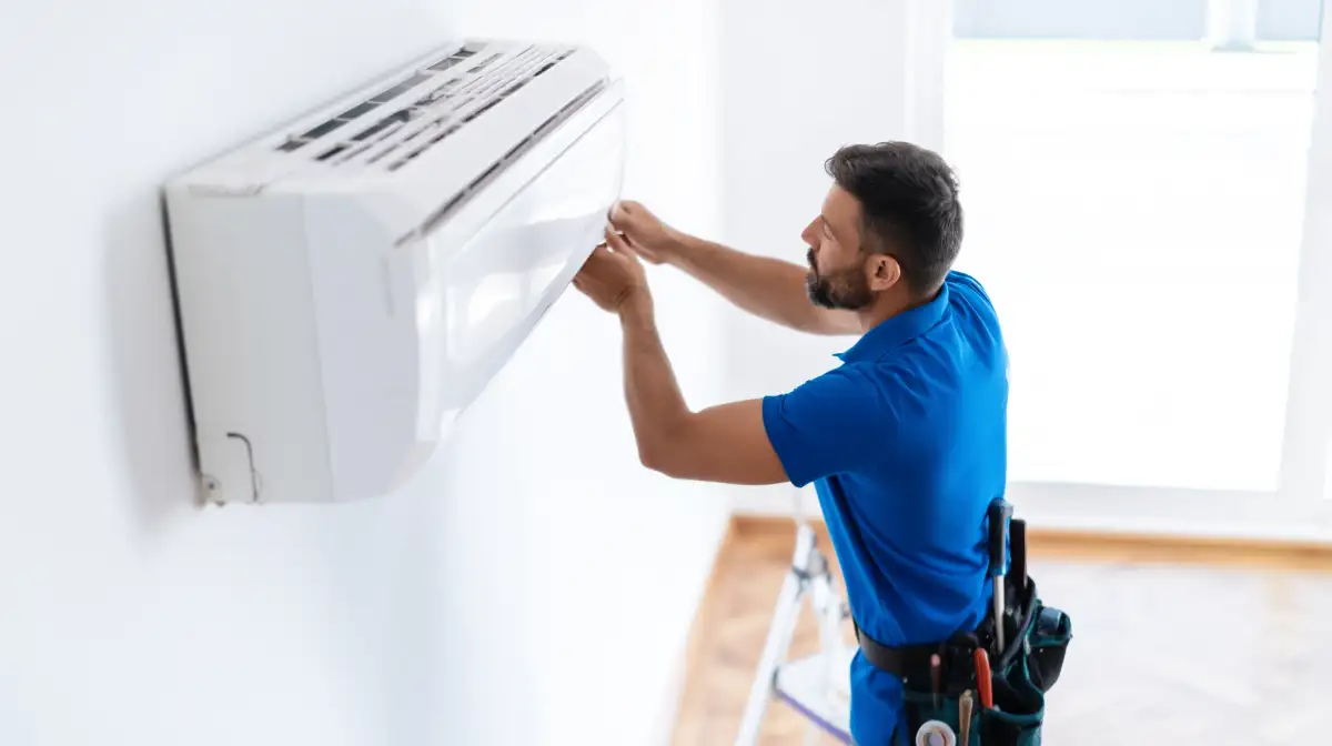 Monteur installeert een airco buitenunit